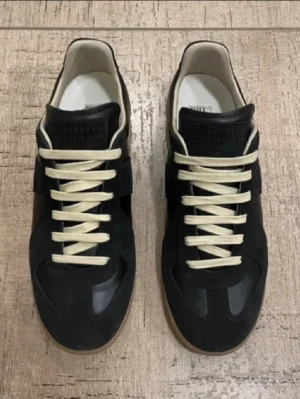 Maison Margiela Gats 41 - ljer mina Maison Margiela Gats i storleken 41. De är svart med vit snören och brun sula. Endast använda max 5 gånger. Nyskick 8,5/10, endast en liten defekt på en sömn och säljs utan innersulan. Skriv vid minsta lilla fundering eller prisförslag!
