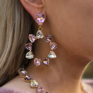 Statement stud örhängen hjärtan - Statement stud örhängen. Hjärtformade kristaller. Färg Light Rose, Light Amethyst och Clear Crystal. Längd 7cm, diameter på cirkel 4,5cm, vikt 17g. Tillhörande halsband som syns på bilden finns i en annan annons.  Jag skickar endast spårbart, samfraktar. Fast pris. Besök gärna mina övriga annonser.  Till mina smycken använder jag kristaller från Preciosa, Aurora och Swarowski.