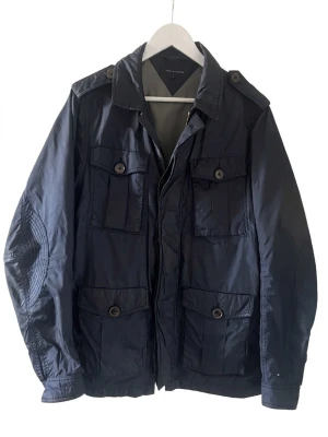 Field Jacket Tommy Hilfiger - Field Jacket från Tommy Hilfiger.                                   Storlek:S                                                                           Färg: Marinblå