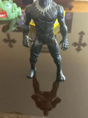 Black Panther cosplay figur - Cool Black Panther figur för maskerad och cosplay. Figuren är svart med silverdetaljer och har en muskulös form, inspirerad av Marvel-karaktären. Perfekt som accessoar till superhjältemaskerad eller cosplay-event.