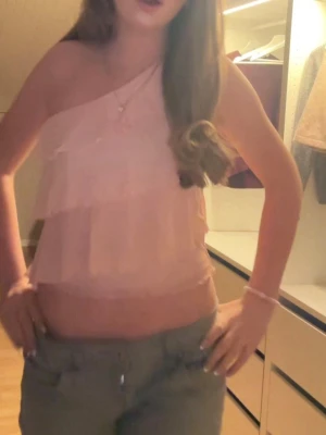 Ljusrosa oneshoulder volangtop - Säljer denna populära ljusrosa oneshoulder topp med flera volanger som inte säljs längre. Supersnygg till sommaren o så skön. Storleken ör 158/164 men sitter som en xs/s. Skriv vid frågor💕