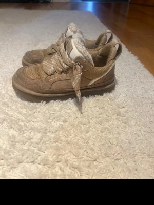UGG Lowmel Sand  - Säljer ett par sand UGG lowmel då de inte kommer till användning längre, de har lite defekter då jeans har färgat av sig längst uppe på skorna, kan gå och få bort har inte provat då jag inte har rätt rengöringsverktyg. 