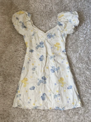 Somrig klänning  - Så fin klänning från NA-KD i storlek 36. Den har korta puffärmar och går att ha både offshoulder och vanligt. Stängs med en dragkedja i sidan. Hör av dig om du har några funderingar 💗