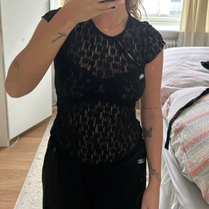 Svart spetsblus med kort ärm - Snygg T-shirt i spets med detalj vid axeln! Den är helt ny men prislapp avtagen❤️