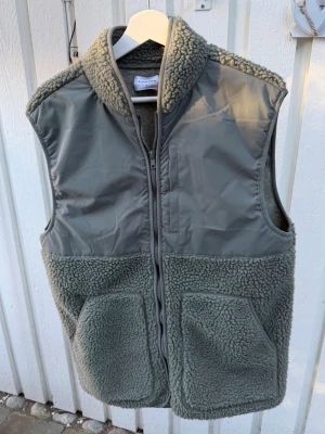 Grön teddy fleece väst herr - Säljer min gröna teddy fleece väst från studio total. Skick: 8/10. Passar perfekt med en stickad tröja under med ett par schyssta jeans. Tveka inte på att höra av dig vid eventuella frågor eller funderingar!