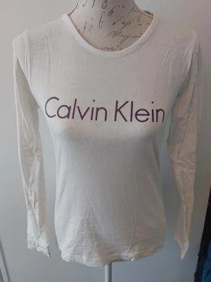 Top Calvin Klein - Top I bomull. Vit med lila tryck.