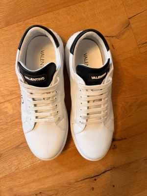 Valentino BOUNCE - Sneakers - white/black - Säljer ett par snygga vita Valentino sneakers. Knappt använda, dem är lite försmå för mig. Storlek 44. Köpte dem från Zalando för 10 månader sedan, nypris ligger på 2595 kr. Säljer dem för 1500 kr.