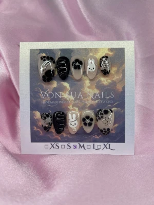 MiffyNoir(M);Short Almond - Unika handgjorda press-on naglar i svart och nude. Naglarna har blommor, 3D nailart linjer och en söt kanin (Miffy). Korta-Mandelformade och handmålade i akryl. Perfekt för dig som vill ha en edgy och gullig look.M: 16 mm, 12 mm, 12,5 mm, 11,5 mm, 10 mm