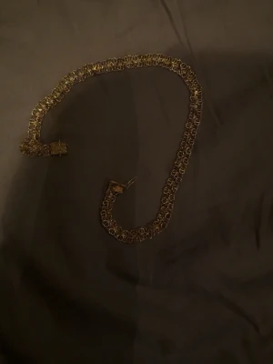 Guldigt kedjehalsband, x länk  - Snyggt halsband i guldfärgad metall med bred kedja och detaljerad länkdesign. Perfekt för dig som vill ha ett statement-smycke som sticker ut. Låset är robust och smycket har en elegant, glansig finish.