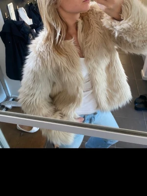 Beige fluffig pälsjacka - Säljer en supermjuk och fluffig beige pälsjacka ifrån HM. Har även som små krokar, så går att stänga jackan. Står tyvärr inte storlek men skulle gissa på att den är en XS.💗