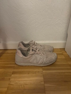 New Balance 373 - Snygga beige sneakers från New Balance i mjuk mocka med klassisk N-logga på sidan. Skorna har lågt skaft, matchande snören och en stilren design som passar till det mesta. Perfekta för dig som gillar en clean och avslappnad look.