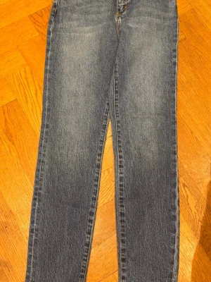 Blå raka jeans från Neuw storlek W26 L30 - Snygga blå jeans från Neuw med rak passform och klassisk femficksdesign. Jeansen är tillverkade i ekologisk bomull och har en lätt tvättad look med subtila slitningar. Perfekta för en avslappnad och trendig stil.