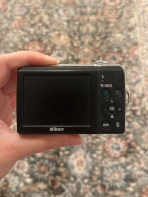 Nikon kamera - Kan både filmas och fotograferas med, funkar bra, den fungerar med batterier och har ett simkort på 4gb.