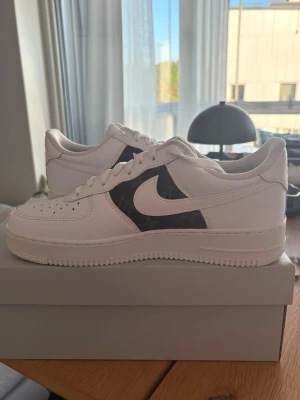 Nike Air Force 1 vit/svart sneaker - Fixade med äkta läder och sydda hos en skomakare. Storlek 43. Gjorde för ca 4 år sen och aldrig använda därav vissa missfärgningar. Helt nya skor annars.