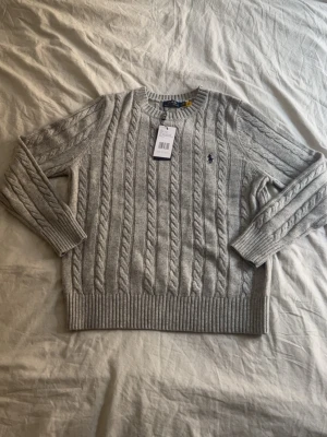 Cable knit  - Jag säljer en grå Ralph Lauren cable knit i size M passar även S. Helt ny, hör av dig vid minsta fundering!