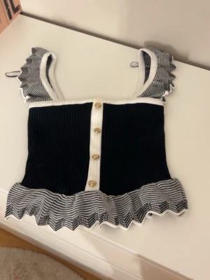 Söt sommartopp - Supersöt svart ribbad topp med vita volangdetaljer. Aldrig använd !