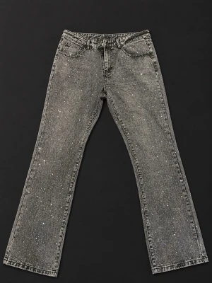 Grå glittriga raka jeans - Snygga grå jeans med rak passform och glitterdetaljer över hela tyget. Jeansen har klassisk femficksdesign och normal midja. Perfekta för dig som vill sticka ut med en cool och trendig look.