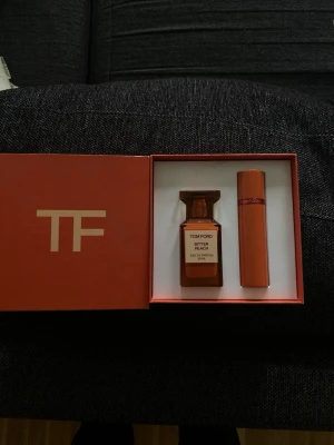 Tom Ford Bitter Peach parfymset - Exklusivt parfymset från Tom Ford med doften Bitter Peach. Setet innehåller en elegant, fyrkantig glasflaska i orange och en matchande cylinderformad sprayflaska. Levereras i en snygg orange box med TF-logga. Perfekt för dig som gillar lyxiga och fruktiga dofter.