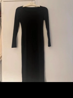 Svart långärmad klänning Shein - En enkel och stilren svart långärmad klänning från Shein. Klänningen har en rak passform och är tillverkad i mjuk polyester med lite stretch för extra komfort. Perfekt basplagg att styla med accessoarer.