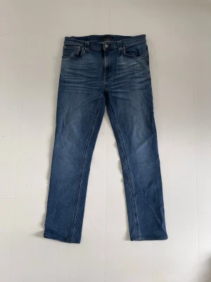 Blå slimfit jeans från nudie  - Säljer ett par slimfit jeans från nudie i modellen Lean Dean med riktigt snygga fades! De har inga defekter och är i storlek W32 L32 men jag skulle även säga att de passar lite mindre så tveka inte att skriva om du har frågor.