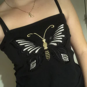Linne fjäril  - Supergulligt linne med en fjäril av paljetter o broderi i silver o guld samt svart. Väldigt bra skick o storlek 42/44 o är 41cm bred på en sida alltså 82cm runt om. Lagom stretchig. Passar mig med xs-s på bysten men blir lös på magen/midjan, så går alltid o sy in. 
