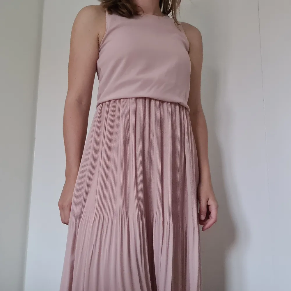 En klänning som jag köpte inför ett bröllop för cirka 3 år sedan. Fint skick, använd 2 gånger. Klänningen går ner till vaderna på mig (är 168 cm lång).. Klänningar.