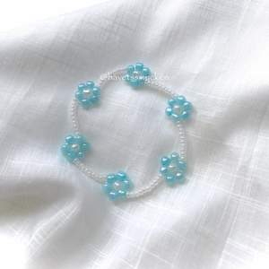 Pärlarmband av skimrande glaspärlor i ljusblå och vit nyans. Perfekt att kombinera med andra smycken! Armbandet är ihopsatt med hållbar elastisk tråd och passar de flesta handleder.