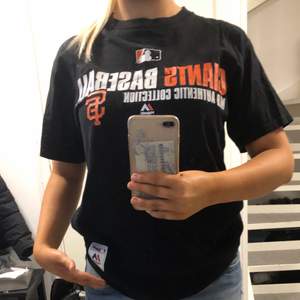 En svart t shirt med giants baseball tryck I stl M