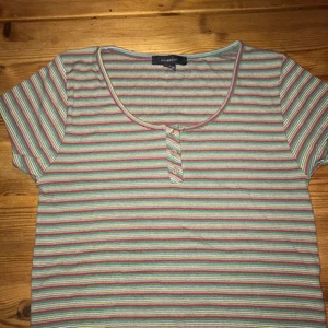 T-shirt  - Kort T-shirt i fina färger med knappar, sitter tight