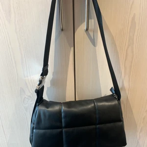 Quiltad väska från Nelly  - Quiltad väska från Nelly, använd endast en gång så i mycket gott skick. Själva väskan är ca 30x17 cm. Snyggt spänne som går att reglera! Tre fack inuti. Hämtas vid Fridhemsplan eller skickas mot fraktkostnad :) nypris 499. 