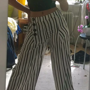 Randiga kostymbyxor - Skitsnygga randiga kosymbyxor från zara. Luftigt och härligt material. 4 knappar vid midjan för dekoration. Byxorna är midwaist och sitter perfekt i midjan och i nice höjd. Använda typ 1-2 ggr, så i princip i nyskick, inga slitningar alls. Jag är 167 och de sitter bra på mig, men kan tänka mig att de passar någon lite kortare än det också😊 hör av dig vid intresse eller frågor