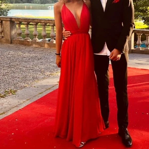 Balklänning - Säljer min balklänning som är använd vid ett tillfälle. Den är justerbar i storleken då man knyter den själv. Nypris på denna var 2.500kr och den är gjord efter beställning. Den första bilden är lånad för att visa bättre hur modellen ser ut. Jag har på de två andra bilderna använt en säkerhetsnål för att göra v-ringningen lite mindre 💓 Jag är 1.70cm och man kan sy upp den om man vill 