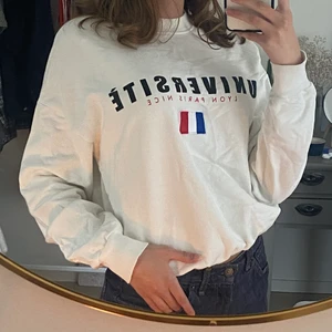 Vit crewneck med tryck - Fin vit crewneck från Gina Tricot! Inte i nyskick men har inga defekter bortsett från en liten missfärgning (bild 3). Storlek XS men lite oversized på mig som brukar vara XS-S så den skulle säkert passa till en M också. Kontakta mig vid frågor🥰