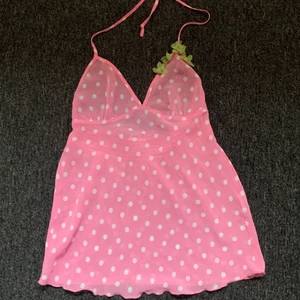 Somrigt linne  - Supergulligr linne, perfekt för sommaren. Superbra skick, mesh tyg, bubbelgumsrosa med vita prickar, refflad nedtill. Söta gröna blommor påsydda. Vet inte vart den är ifrån då jag fått den av min faster som ej använde den. ⭐️köpare står för frakt⭐️