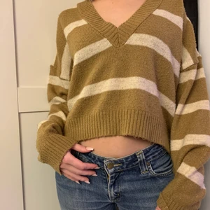 Stickad tröja - Superfin beige/brun stickad tröja från NA-KD med ränder. Tröjan är i storlek XS men skulle även passa S. Den är använd men känns och ser ut nästan som ny! Frakt tillkommer!