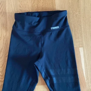 Stronger träningstajts  - Jag säljer dessa svarta träningstajts ifrån Stronger. Använda bara ett fåtal gånger och i väldigt bra skick! 