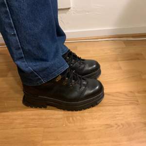 Svarta Caterpillar boots med metalldetaljer i storlek 43. De är nästintill nya och har bara använts några gånger. Skorna är ganska höga men de känns inte klumpiga. Priset kan diskuteras