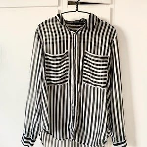 Svartvit randig skjorta - Fin skjorta med svartvita ränder i chiffongtyg. Perfekt till våren! Storlek M. 