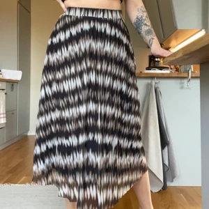 Lång kjol med mönster - Lång kjol från Vila. Skönt meshmaterial, svart underkjol så den blir inte genomskinlig. Strl M. Nyskick, använd en gång. 