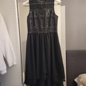 Svart/glitter festklänning - Superfin svart & glittrig festklänning med volang, dragkedja baktill samt knäppe i nacken, köparen står för frakt 🤍