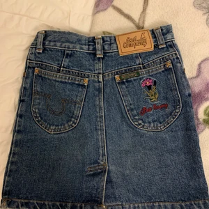 Snygg jeanskjol - Jeanskjol från best company med snygga detaljer på baksidan och en liten slits. Är 158cm och kjolen är ganska kort på mig.