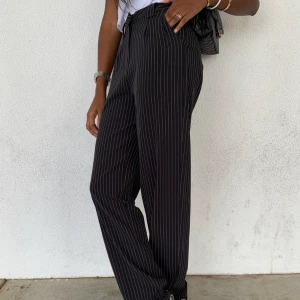 Randiga, vida kostymbyxor  - Säljer ett par svarta kostymbyxor med vita ränder i storlek 34. Väldigt snygg passform. Ungefär ett halvår gamla, men använda max 7 gånger då de sitter för tight i min midja. Jag har i vanliga fall storlek s/m men skulle säga att de passar xs-m(med lite mindre midja) har själv problem med väldigt svullen mage och därav blir dem för tighta. Ena sömmen har lossnat på byxbenet, lättfixat, dock syns det knappt och därav har jag inte fixat det. Fler bilder finns. Kan mötas upp i Göteborg eller Karlskrona. Annars får man stå för frakten. Byxorna är köpta för 499kr. 