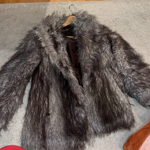 Fuskpäls  - Grå/brun kort fuskpäls. Buda från 200 kr