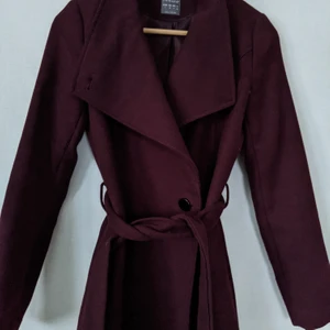 Vinröd kappa - Vinröd kappa från Primark. Supersnygg men inte använd den så mycket så det har legat mest i garderoben