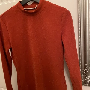 Turtleneck  - Långärmad turtleneck från GESTUZ. Knappt använd. Väldigt fin orange färg på tröjan med en aning glitter i. Super snygg till fest!