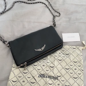 Zadig rock bag - Säljer min fina väska från Zadig & Voltaire! Nypris ca 3200kr. Det medföljer två kedjor i olika längder samt dustbag och äkthetsbevis. Mått ca 15x26 cm. Väskan är i väldigt bra skick och har nästan inga defekter annat än små rynkor där väskan böjer sig när man bär den (bild 3). Annars är kvaliteten väldigt välbehållen! Är du intresserad skriv privat🧚🏼‍♀️❤️