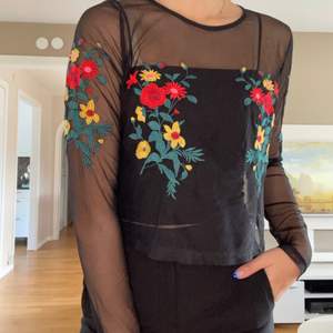 Svart mesh tröja med Blom detaljer på bröstet och ärmen