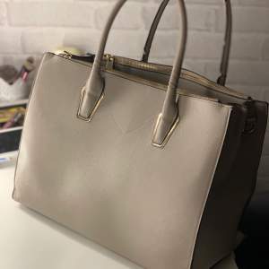 Väldigt fin, beige väska med guldiga detaljer och mycket rymlig🥰 Något slitage på handtaget (se bild) men tycker inte det påverkar helheten❤️ Köpt på H&M ❗️Frakt tillkommer❗️