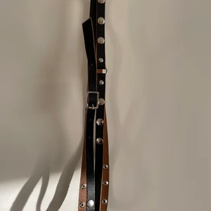 Nitbälte - 82 cm på mittersta knäppet, finns två hål till på vardera sida.