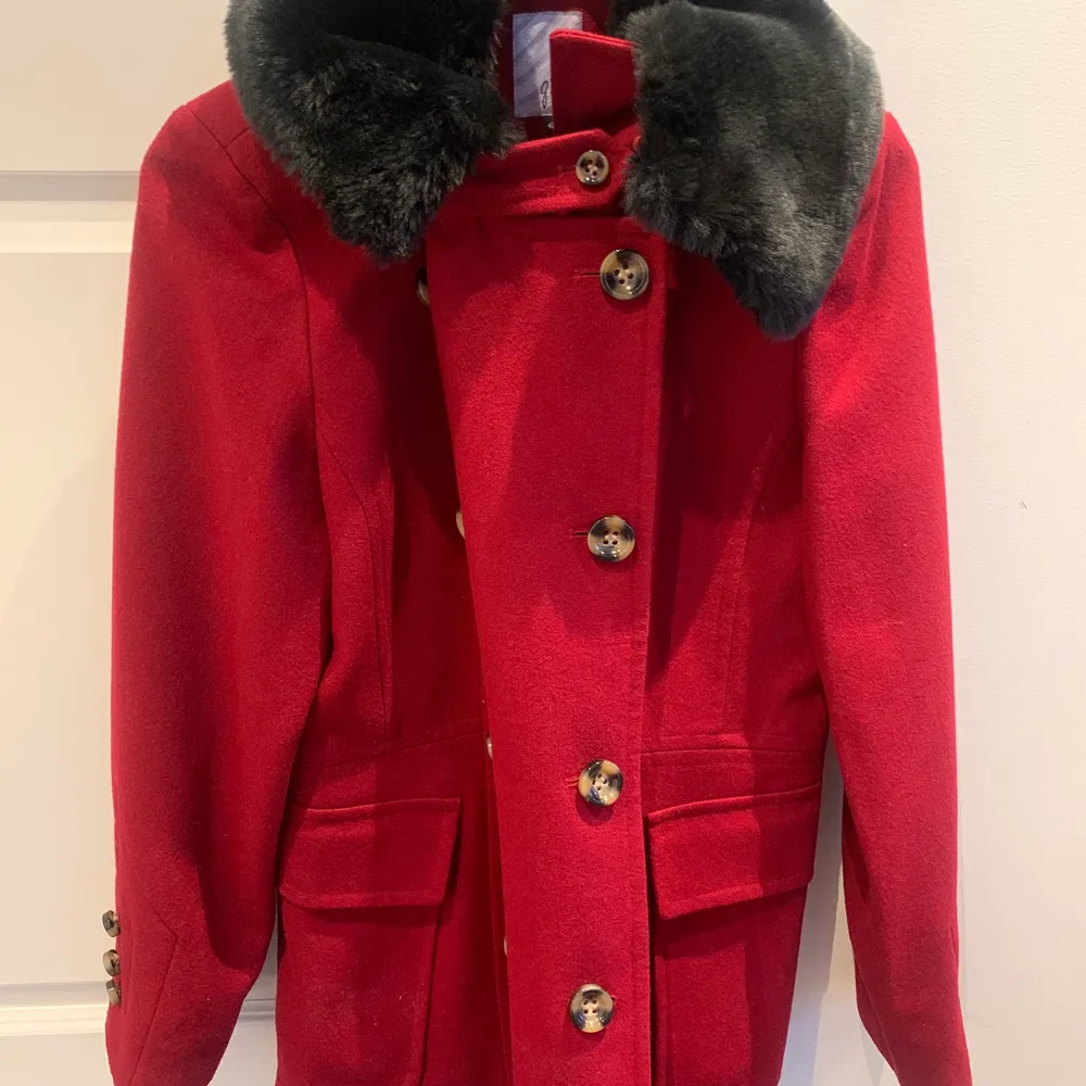 En röd kappa med en fantastisk päls (inte äkta). Skick är nästan som helt ny . Jackor.